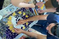 Collaborateurs en train de composer une œuvre collective en mosaïque avec MadCityZen. | © MadCityZen