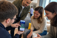 Team building Mini Jeux Digitaux - equipe de collegues jouant ensemble sur smartphone au bureau | © MadCityZen