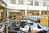 Le restaurant du Hilton Roissy propose une cuisine moderne et généreuse dans un cadre spacieux et lumineux, sous une majestueuse verrière. Idéal pour les repas d’affaires, les déjeuners sur le pouce ou les dîners plus détendus, il offre une atmosphère con | © Hilton Roissy Charles de Gaulle