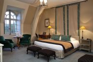 Une chambre raffinée et chaleureuse, mêlant confort moderne et charme classique, pour une nuit paisible au sein du château. | © CHATEAU GOLF D'AUGERVILLE