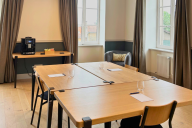 Intime et feutrée, la petite salle de réunion du Carré Fourvière se niche au cœur des espaces patrimoniaux, protégée par ses voûtes basses en pierre blonde. Équipée d’un mobilier sobre et modulable, elle offre un cadre propice aux échanges restreints : ta | © Carré Fourvière