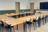 Aménagée en configuration « fer à cheval », cette salle de réunion allie convivialité et efficacité. Le mobilier dispose les participants face à face, favorisant l’interaction et les échanges dynamiques. Éclairée par la lumière naturelle filtrée des fenêt | © Carré Fourvière