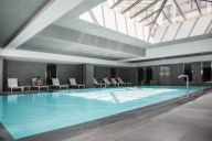 Au cœur du Spa Nuxe, la piscine intérieure séduit par son design épuré et son ambiance zen. Entourée de bains à remous, transats et éclairages tamisés, elle invite à une parenthèse de relaxation absolue. | © Relais Spa Val D'Europe