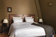 Une chambre confortable au design soigné, mêlant mobilier vintage et touches contemporaines, propice à la détente. | © Hôtel Rochechouart