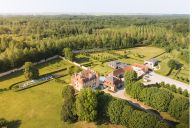 Depuis le ciel, le domaine se révèle dans toute sa splendeur : bâtiments historiques, jardins structurés et vastes espaces naturels se déploient dans un cadre paisible et préservé. | © Château de la Trye