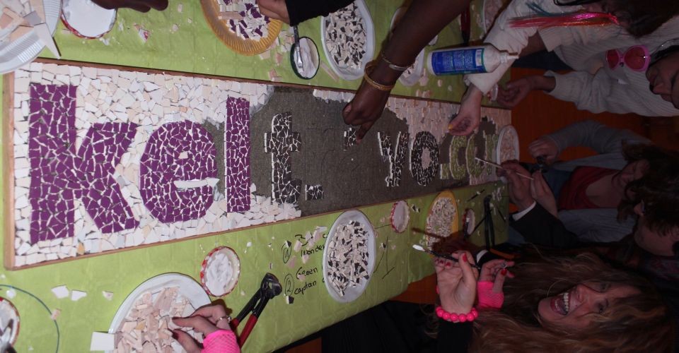 Groupe de salariés créant une fresque collective en mosaïque lors d'un team building.
