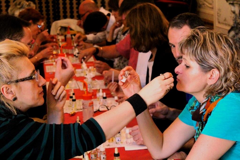 Groupe de collègues créant des parfums et se faisant sentir des fragrances lors d'un team building.