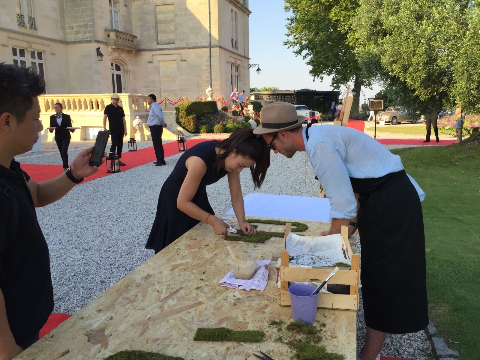 Une femme découpant des lettres dans des matériaux végétaux, lors d'un team building écologique.