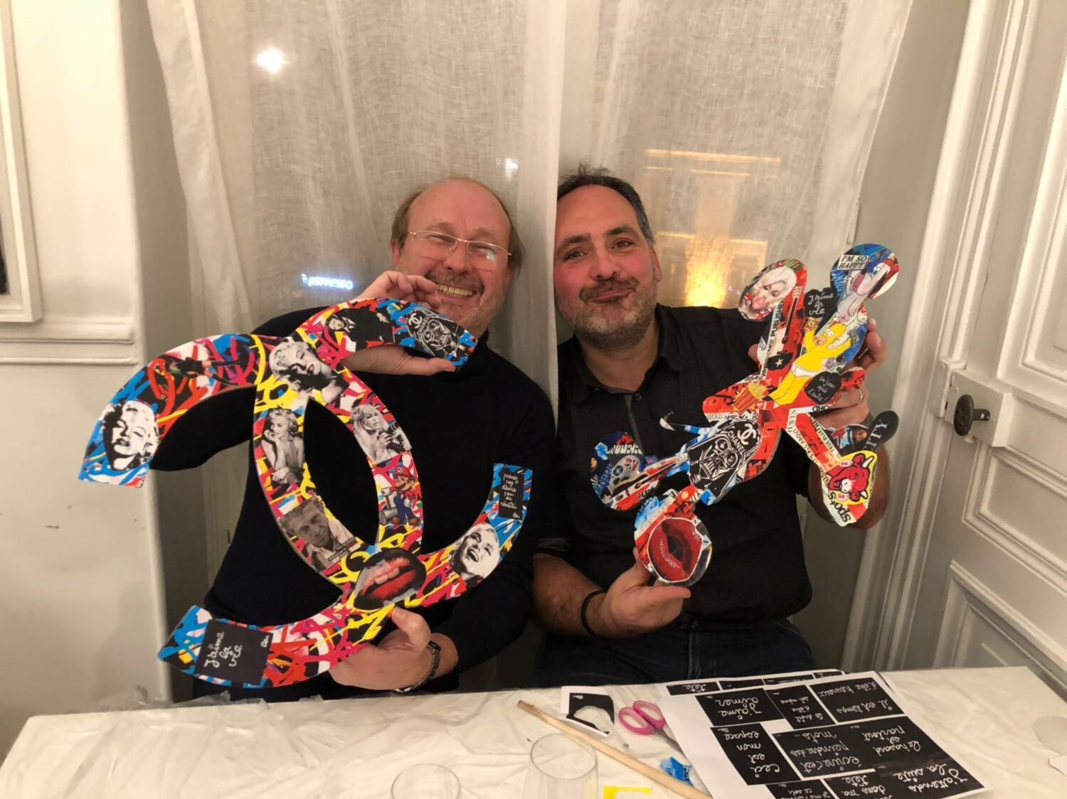Paire de collègues montrant avec fierté et amusement leurs créations lors d'un team building Pop Art 3D.