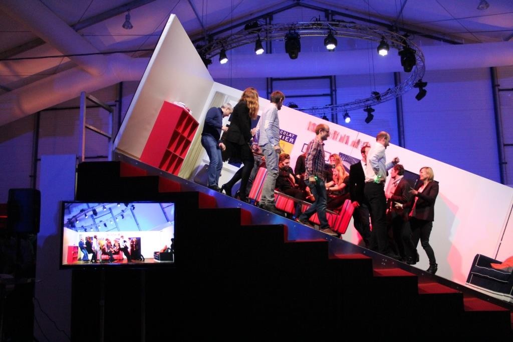 Des employés participant à une activité de théâtre d'impro sur un décor penché pendant un team building.